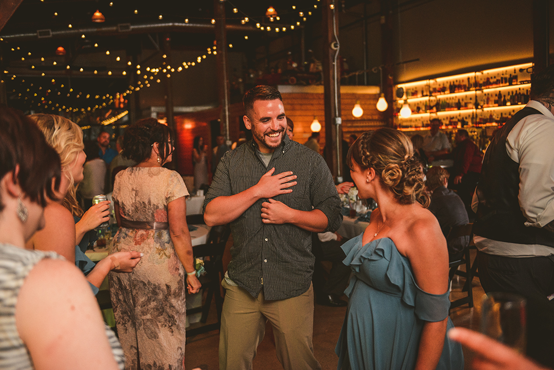 man laughing at his wife at a wedding reception at Warehouse 109