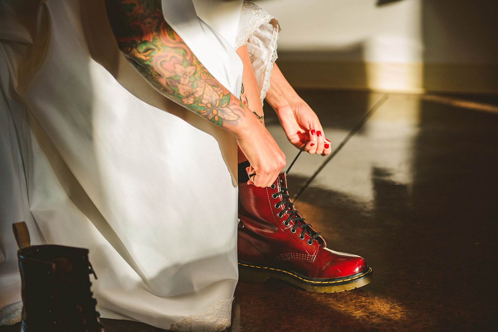 a tattooed bride putting on her red boots at the Four Rivers Environmental Education Center