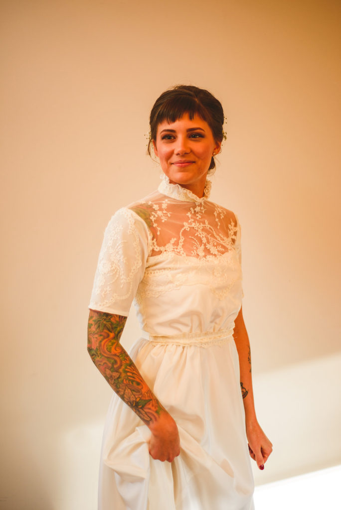 a beautiful bride holding her dress up as she smiles at her friends at the Four Rivers Environmental Education Center