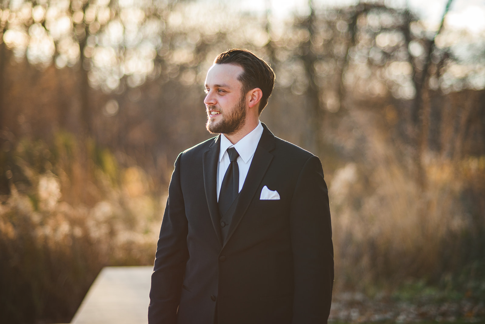 the groom standing outside on a fall evening while he gets ready for the wedding ceremony at Four Rivers Environmental Education Center