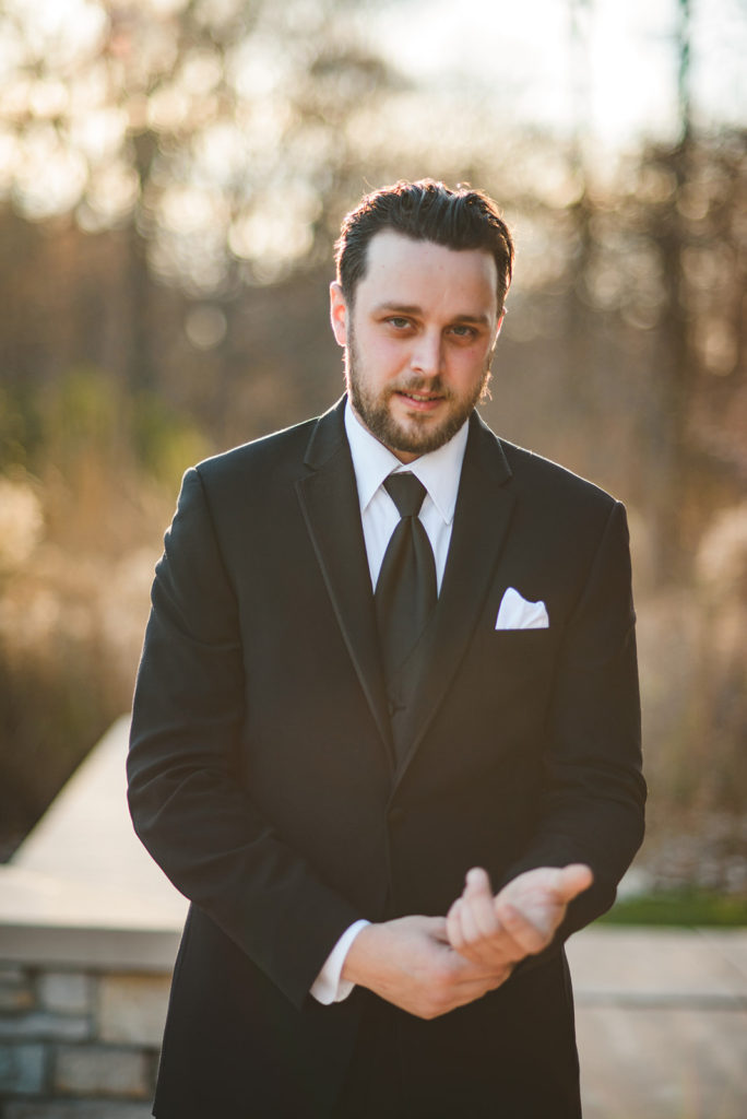 the groom adjusting his cuff outside of the Four Rivers Environmental Education Center