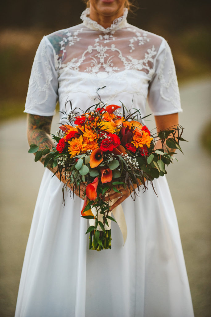 a closeup of the brides flowers and her mothers wedding dress in the evening light of fall