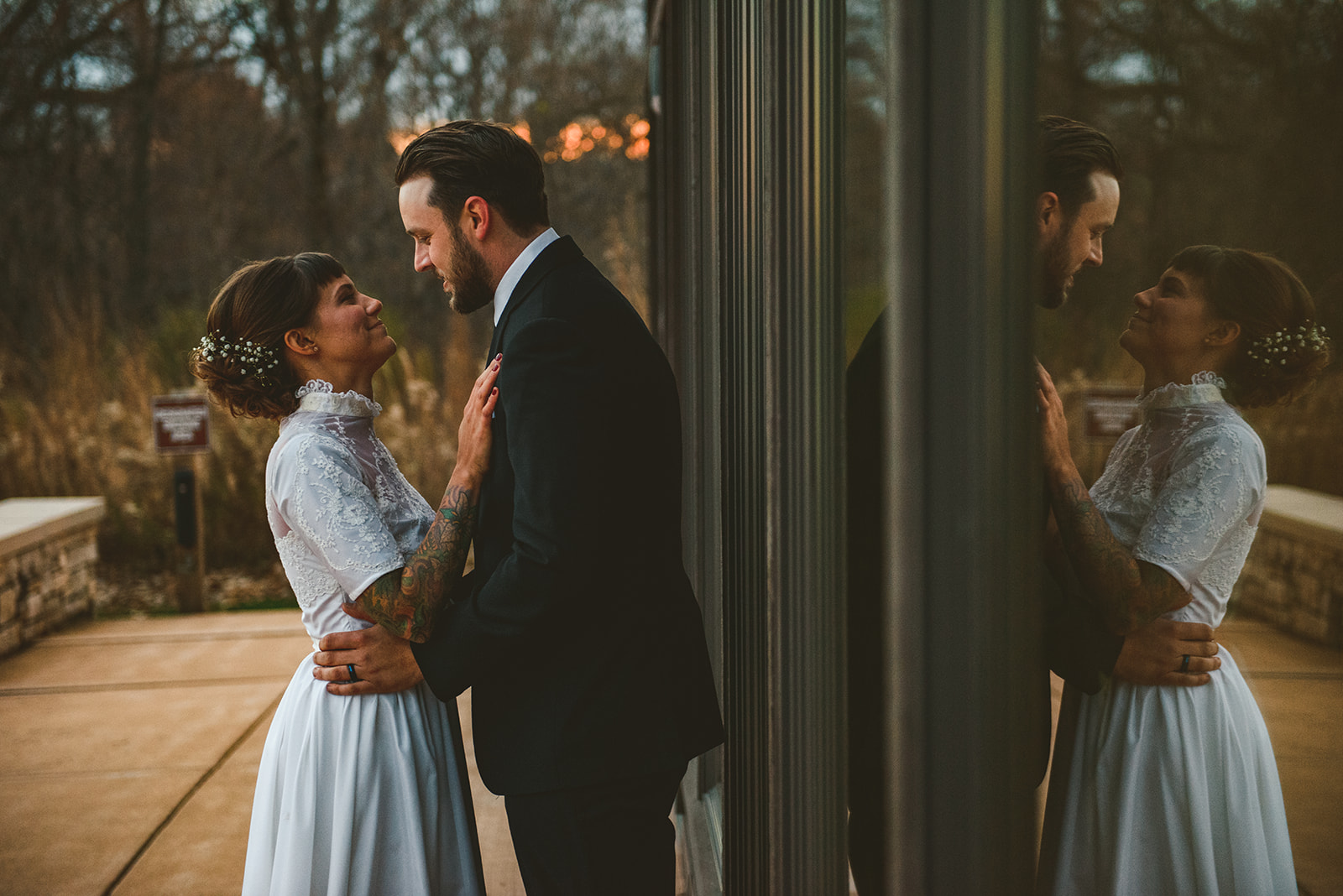 a bride and groom looking into each others eyes in front of windows with their reflections