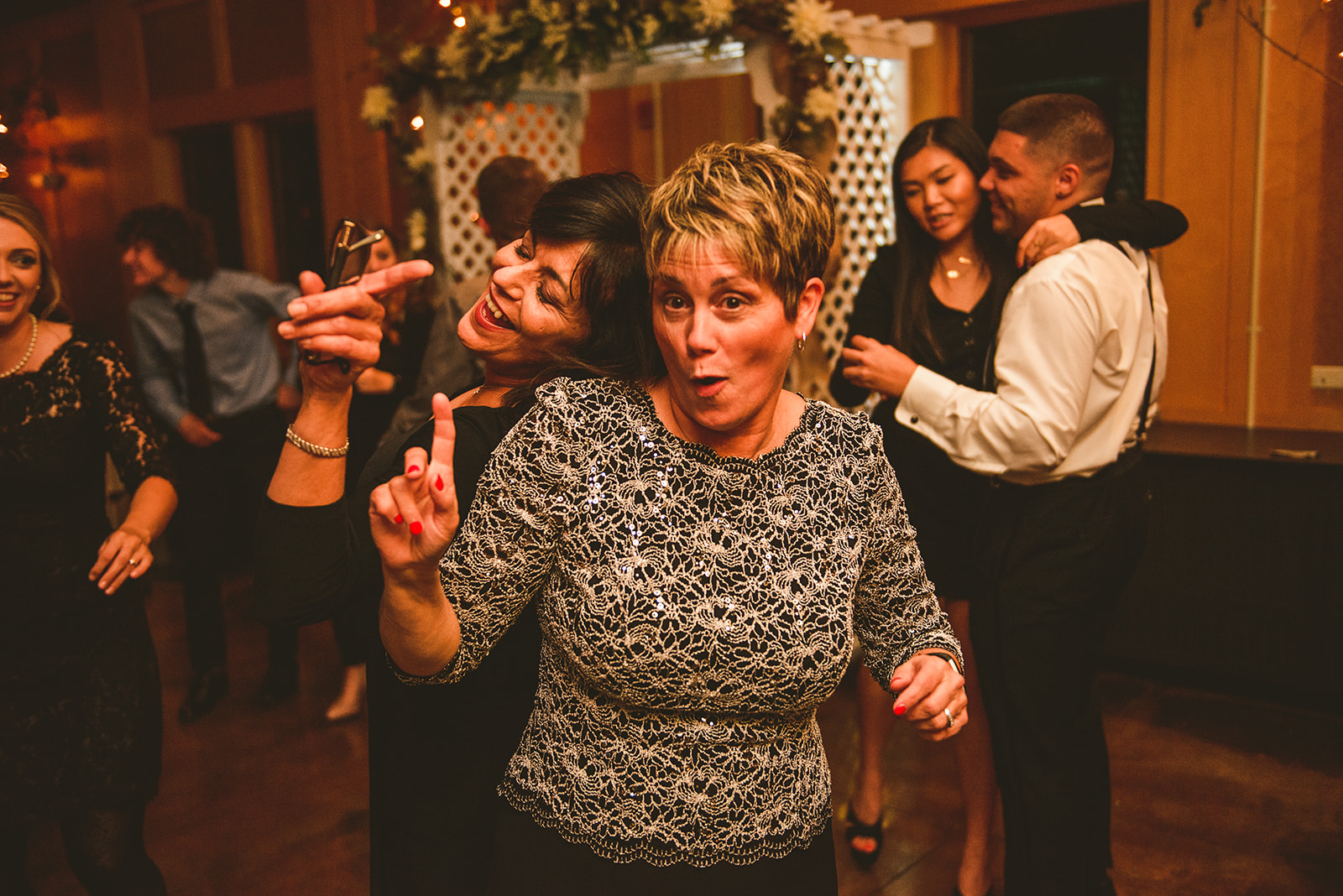 the mother of the bride dancing with her friends as the both laugh