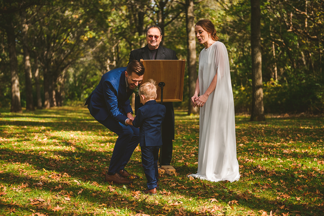 a little boy delivering the rings to the bride and groom during a wedding at the Saint James Farm in Warrenville IL