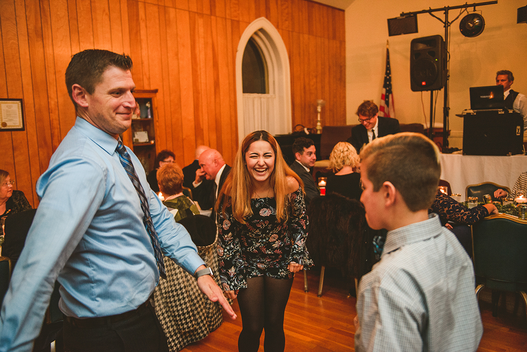 a young girl laughing as her dad dances funny at a Naperville wedding reception