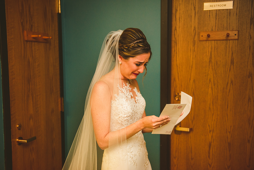 a bride crying after reading a letter from her husband at St Thomas Church in Naperville