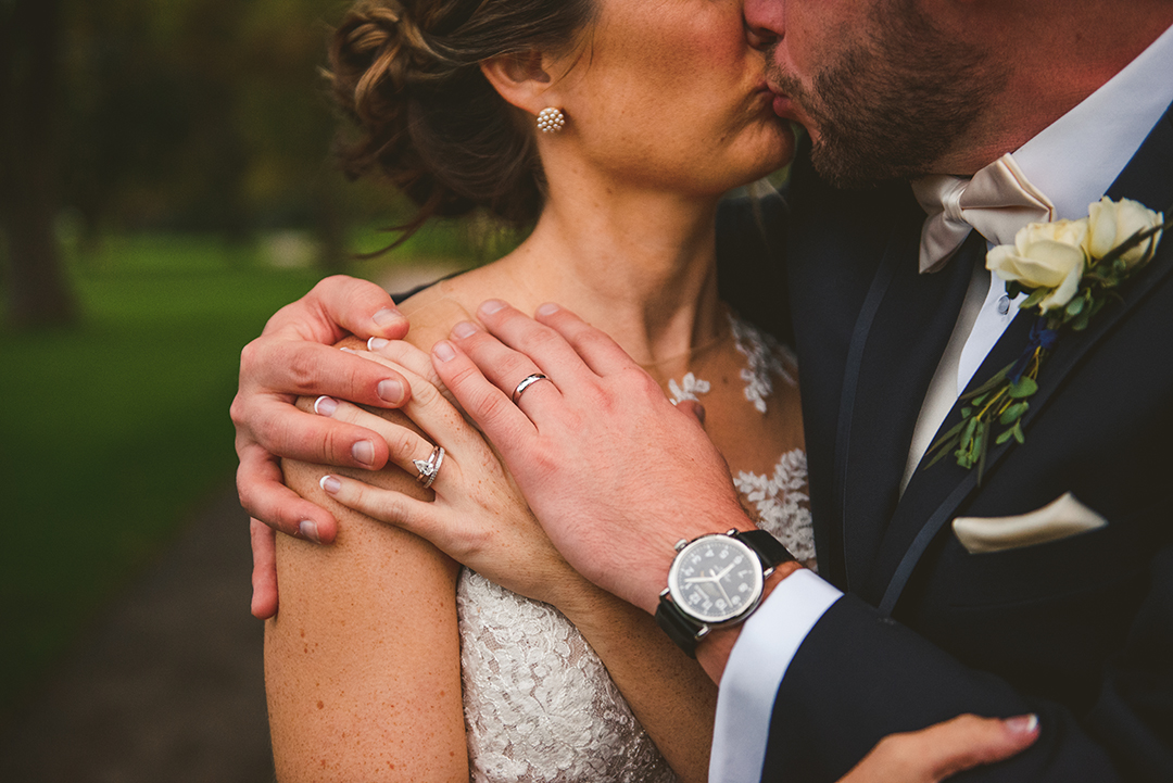 a bride and groom holding onto each other as they show off their rings at the Cress Creek Country Club in Naperville