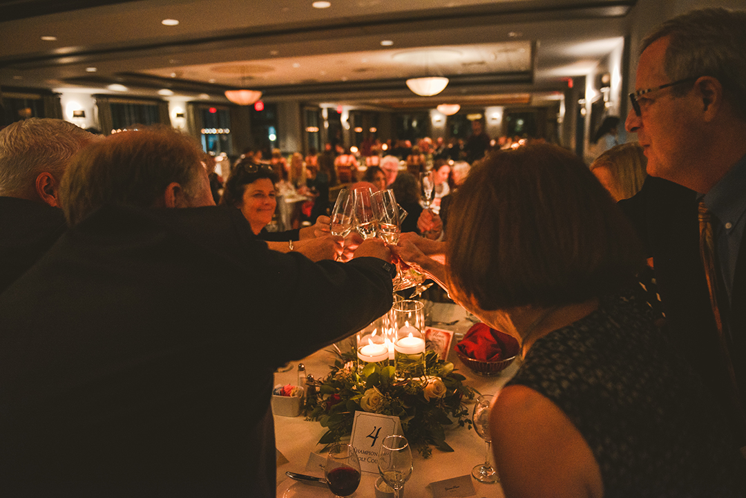 a bunch of wedding guests toasting the couple at a wedding reception at the Cress Creek Country Club in Naperville