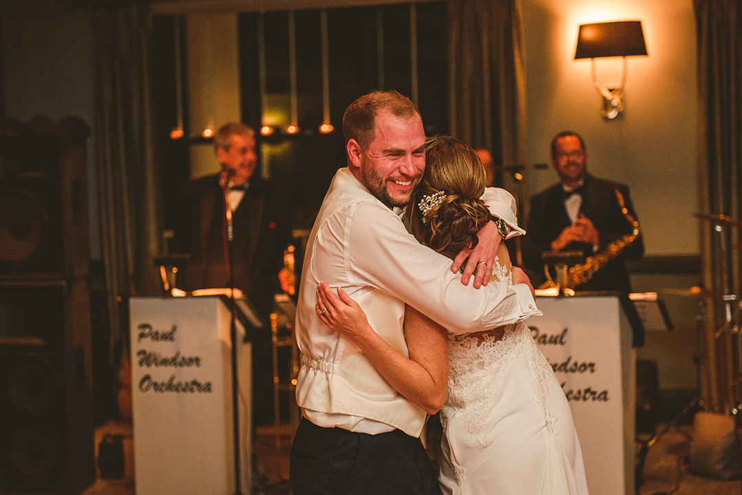 a groom hugging his bride at the end of their first dance at the Cress Creek Country Club in Naperville