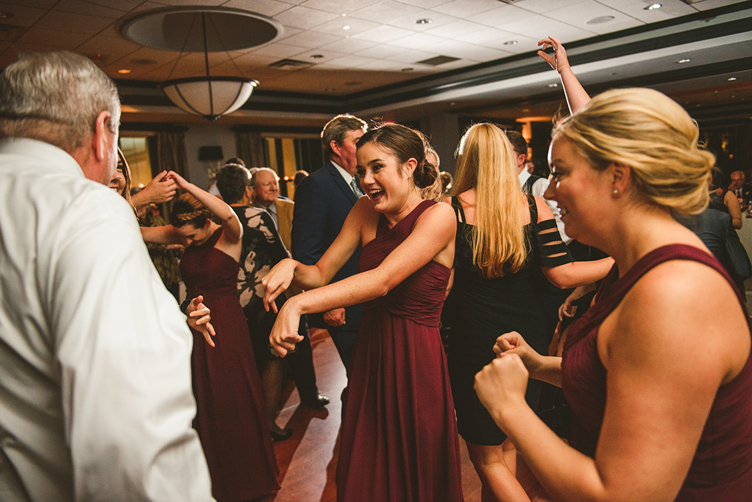 bridesmaids dancing as they laugh in their flowing dresses at the Cress Creek Country Club in Naperville