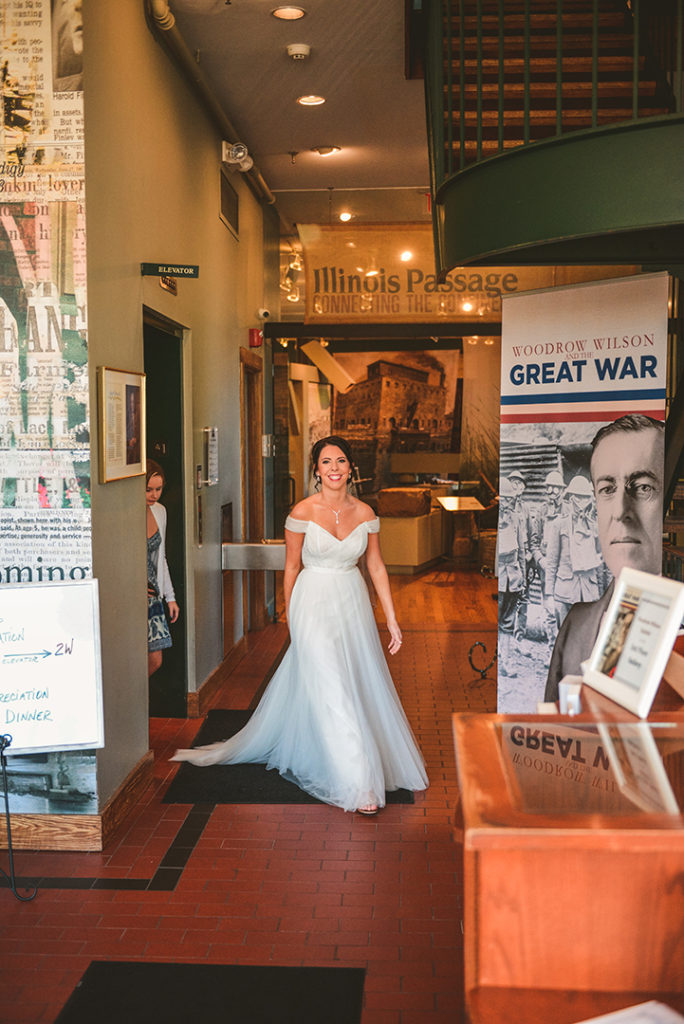 a bride coming out of an elevator as she walks to see her groom for the first time