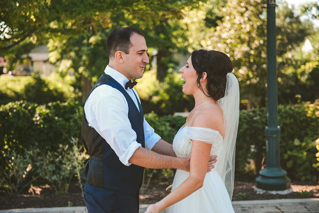 a bride laughing as her groom sees her for the first time before their wedding at a park in Lockport IL