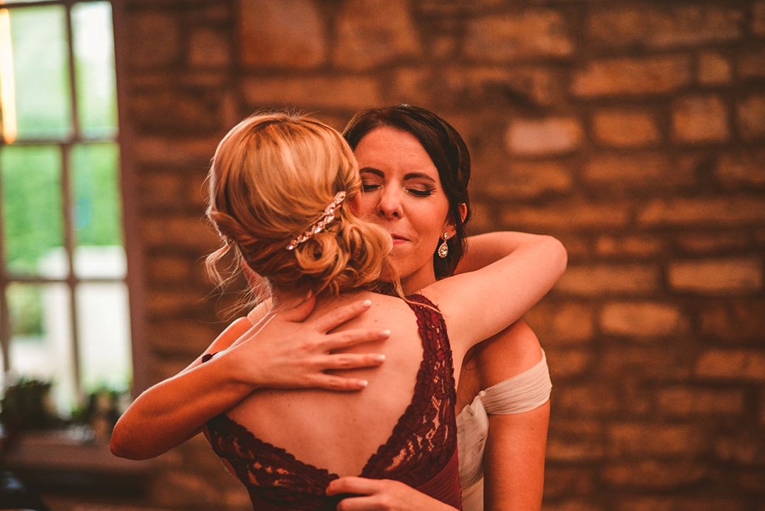 the bride hugging her maid of honor after giving a speech
