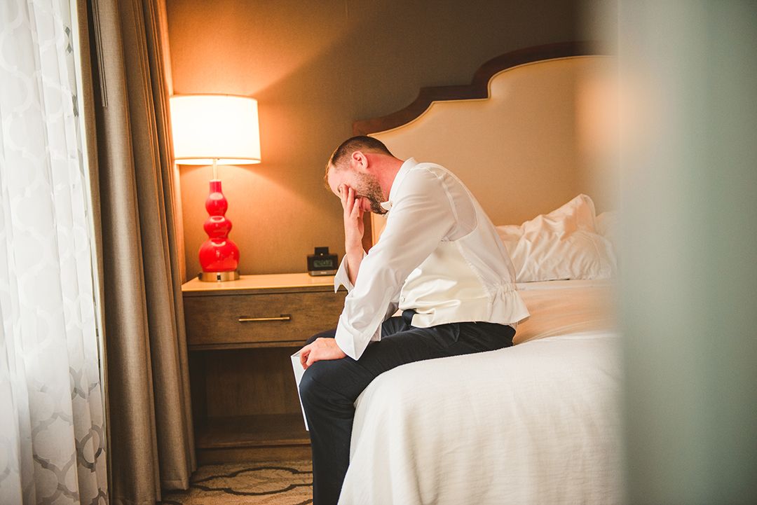 a groom crying as he reads a letter from his bride right before his wedding at St Thomas Apostle Church in Naperville