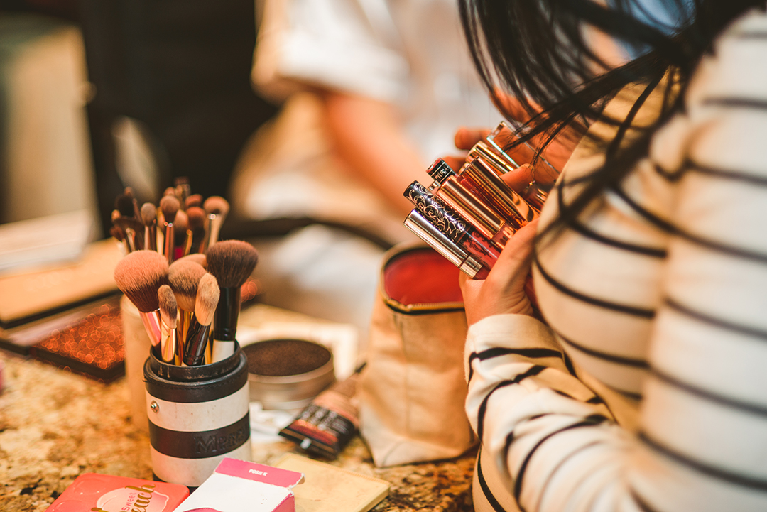 the makeup artist searching for a brush in her bag as she does the brides makeup at a home in Naperville IL