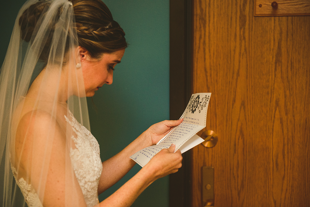 the bride reading a note from her groom at St Thomas Apostle Church in Naperville