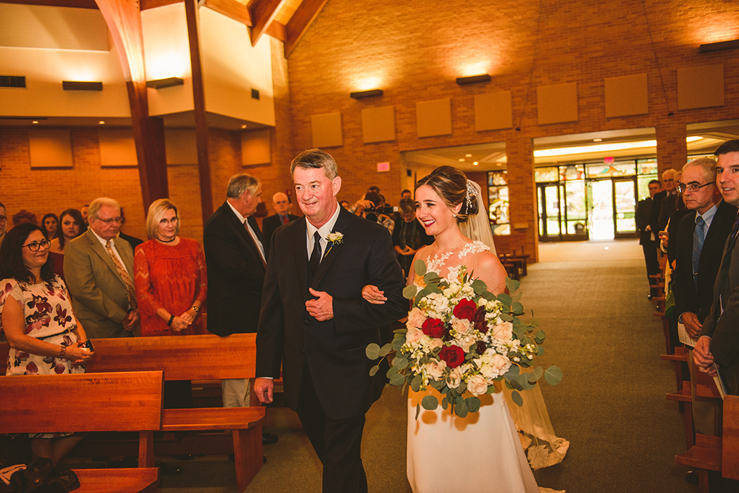 the father of the bride walking his daughter down the aisle at St Thomas Apostle Church in Naperville