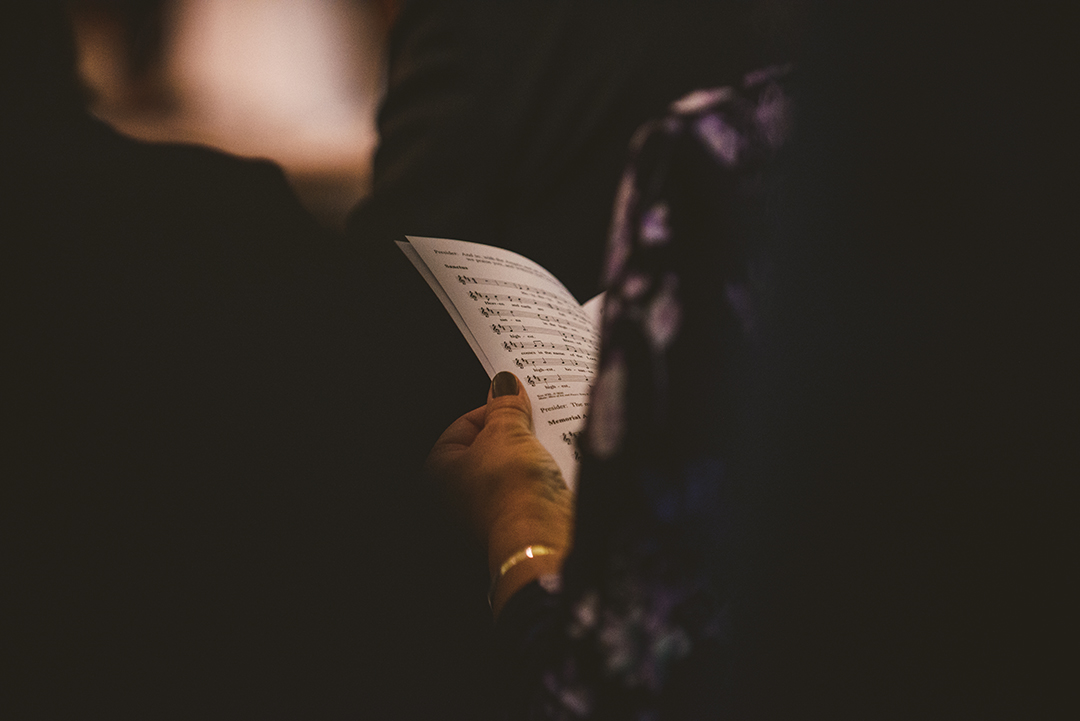 over the shoulder of a woman holding the wedding program at a wedding at St Thomas Apostle Church in Naperville