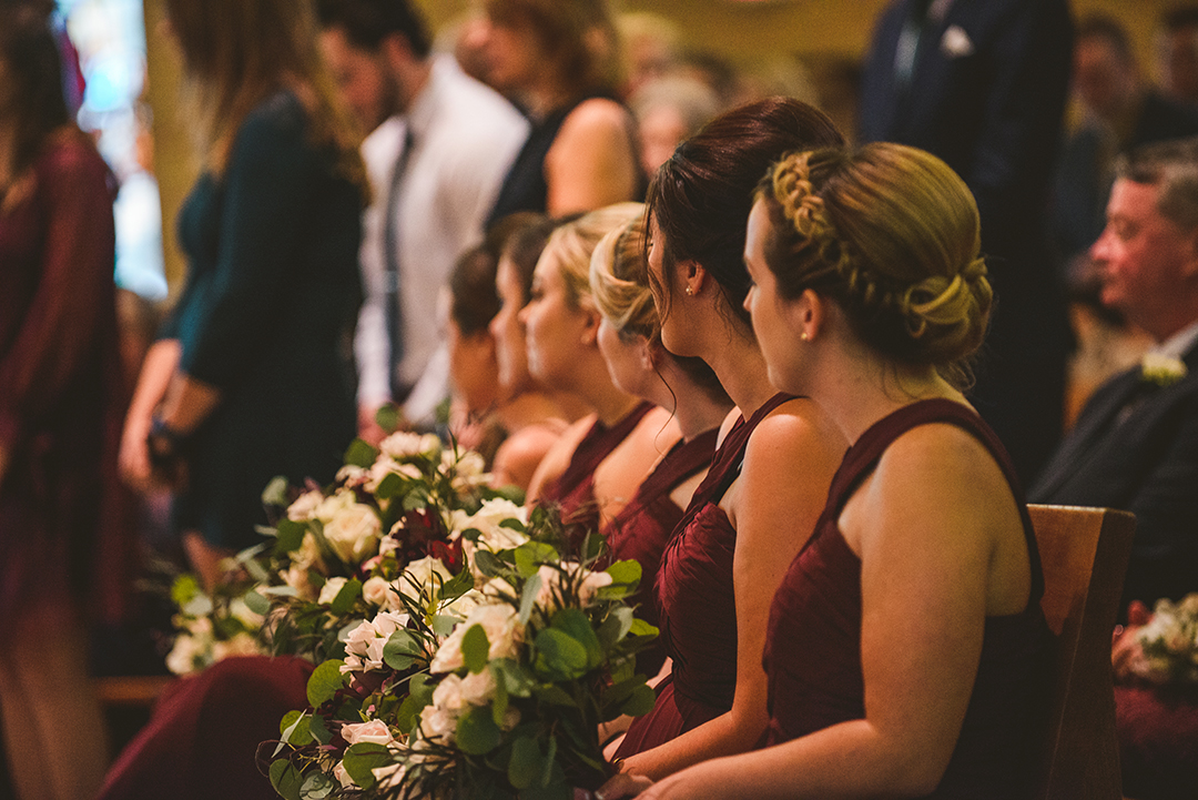 the bridesmaids in a row as they watch the bride and groom get married