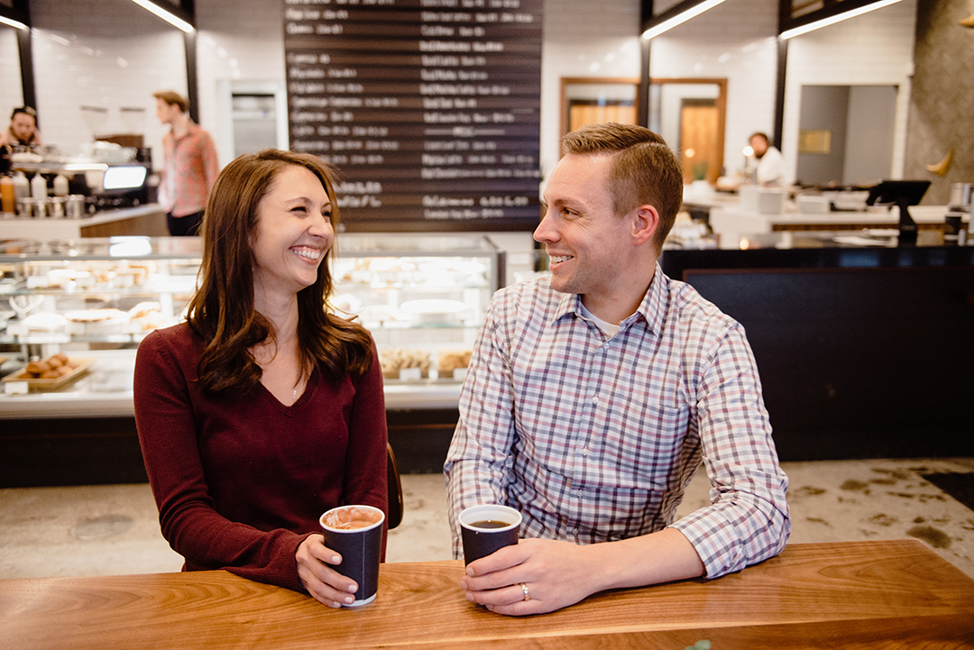 a couple laughing at Sparrow Coffee in Naperville as they enjoy a cup of coffee