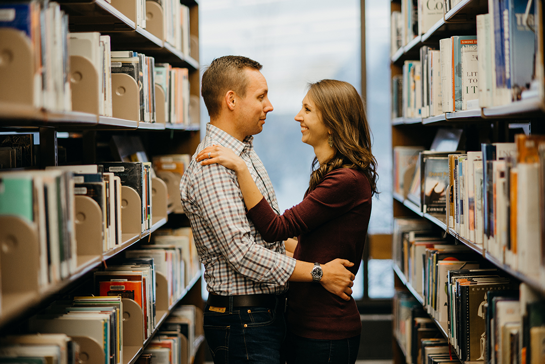 a bride and groom looking into each others eyes as they stand in a library in downtown Naperville