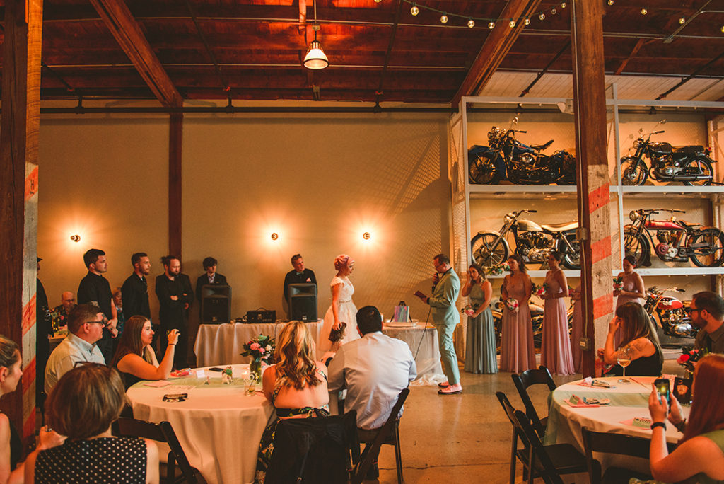 A wedding taking place at the Warehouse 109 in Plainfield in front of the wall of motorcycles
