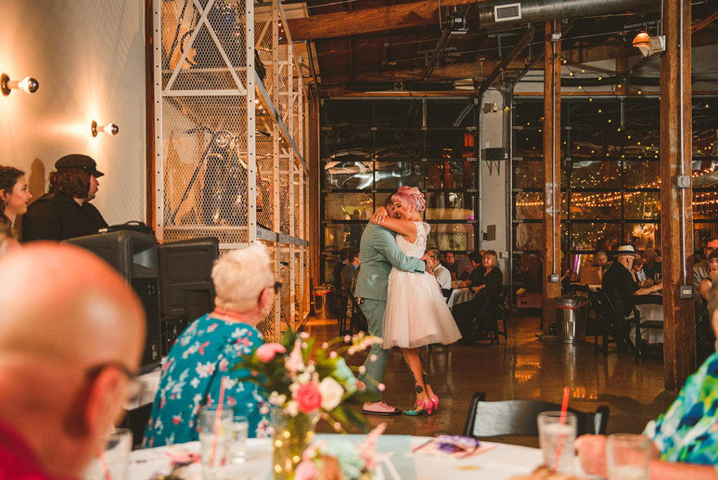 The bride and groom dancing their first dance at the Warehouse 109 in Plainfield as wedding guests watch