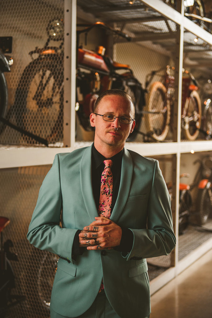 a tattooed groom standing in front of motorcycles at the Warehouse 109 in Plainfield