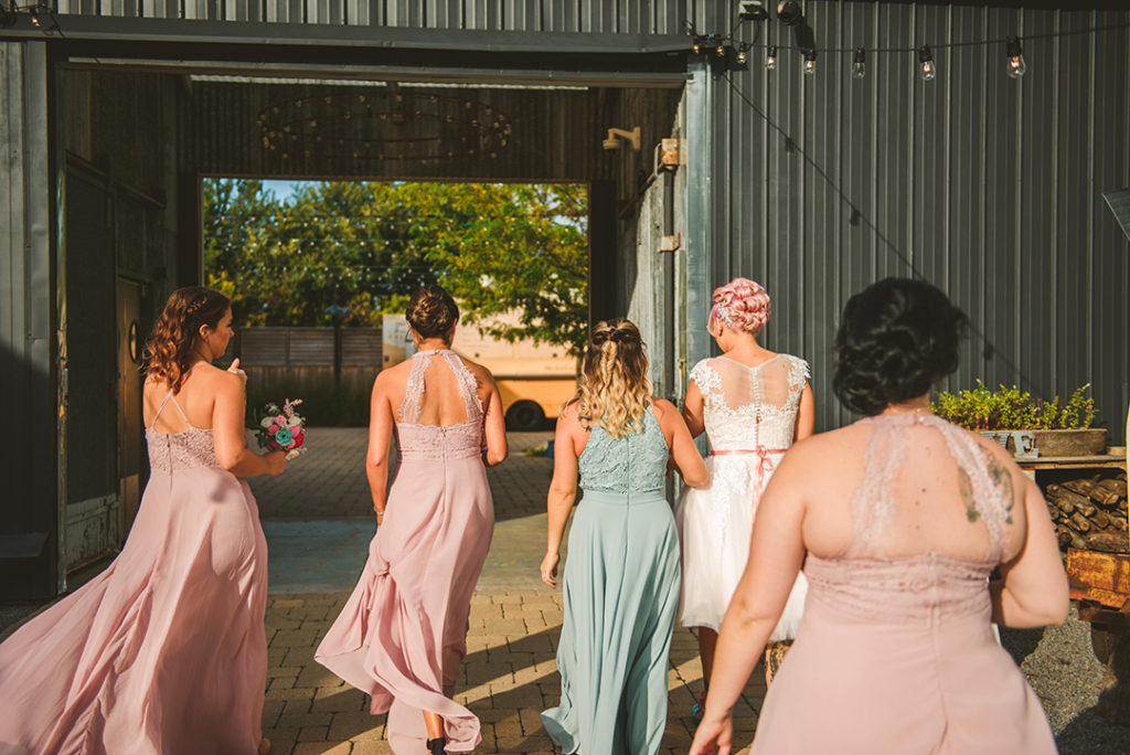 the bridesmaids walking together as they head into the patio of Warehouse 109
