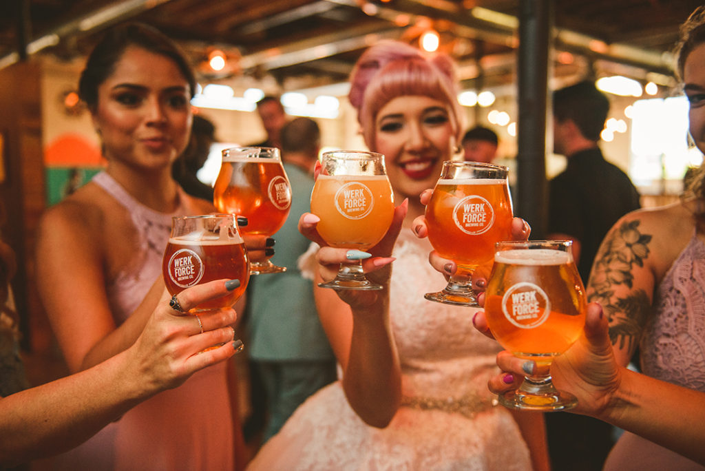all of the bridesmaids holding up their glasses at the Werkforce Brewing in Plainfield IL