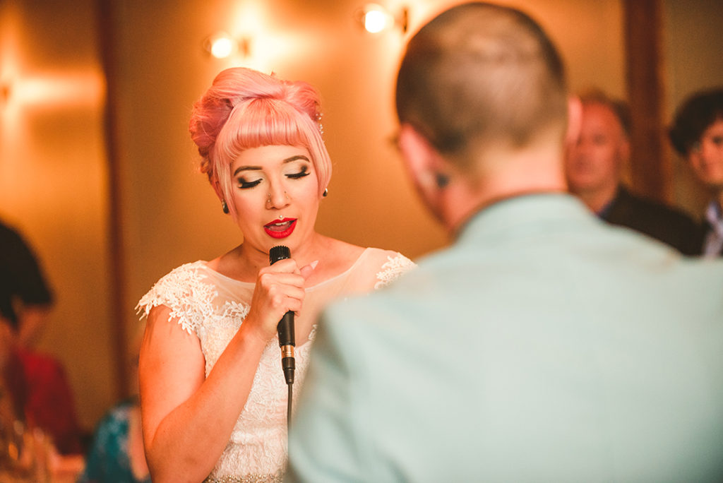 a tattooed bride reading her vows to her husband at the Warehouse 109 in Plainfield IL