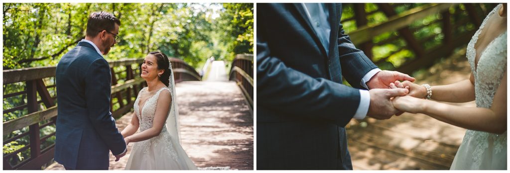 a bride and groom holding hands during their first look at a lake wedding