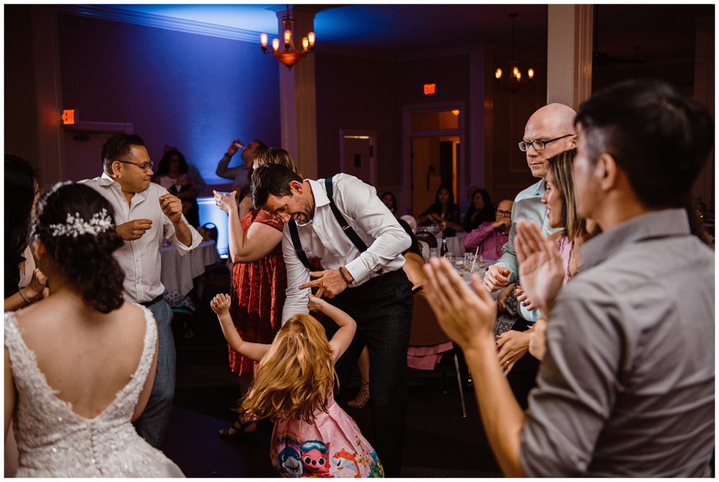 the best man dancing with a little girl after a summer lake wedding at Epiphany Farms Restaurant in Bloomington Illinois