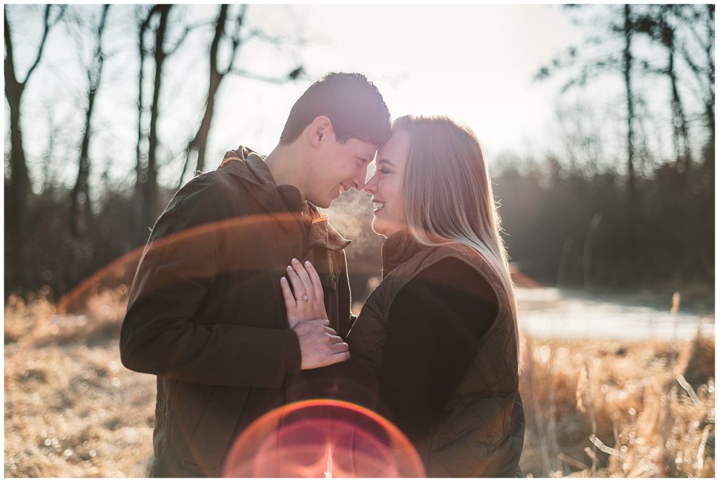 Rustic Engagement Photos of a bride and groom with their heads together as they laugh and hold onto each other