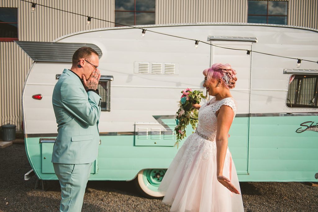 the groom seeing his bride for the first time in from of a vintage trailer at Warehouse 109 in Plainfield IL