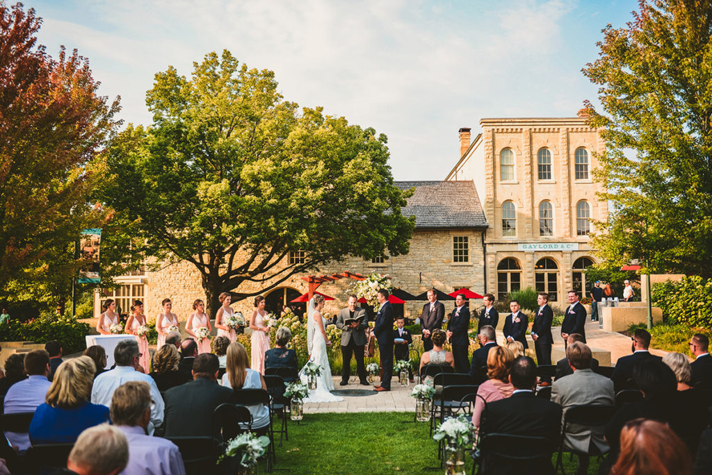 a wedding taking place at a historic building at sunset in the summer
