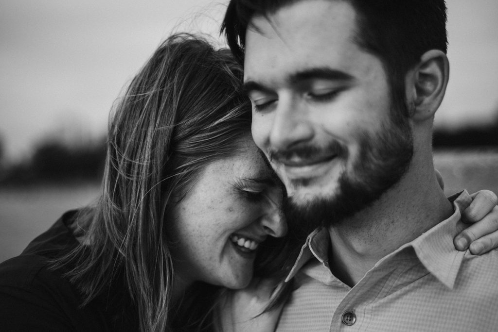 a woman laughing as she gets close to her fiance with the Chicago skyline in the back ground