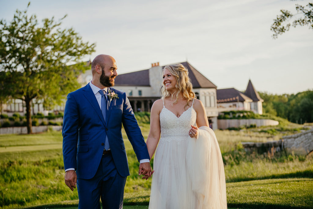 a married couple walking as they hold hands on the putting green of Mistwood Golf Club