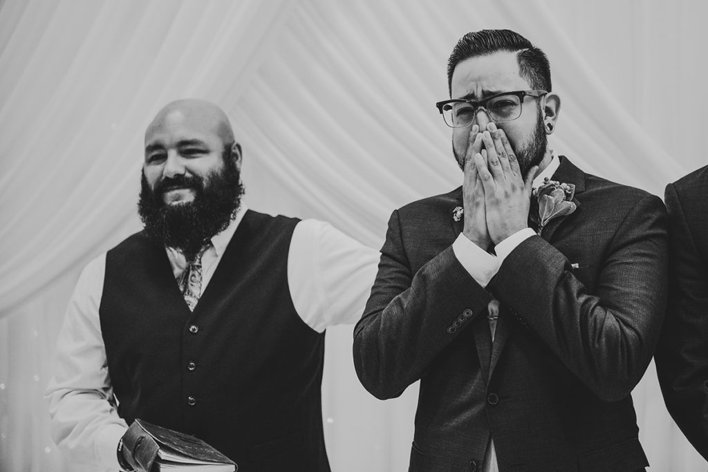 a groom crying as he sees his bride for the first time at their wedding ceremony