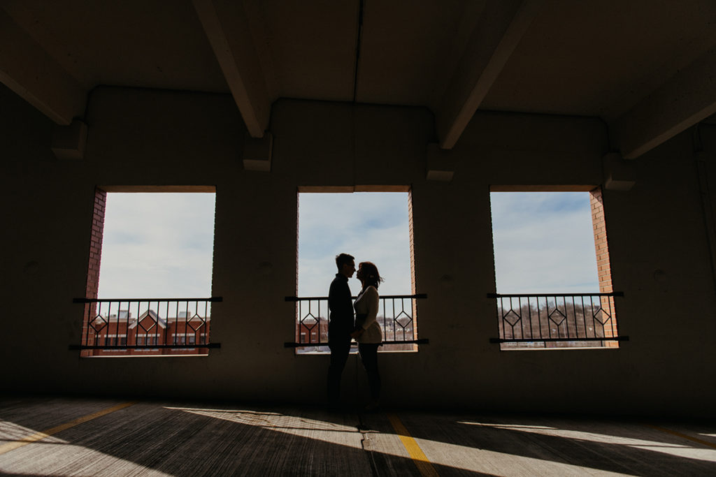 a silhouette of a man and a woman going in for a kiss at their alternative engagement session