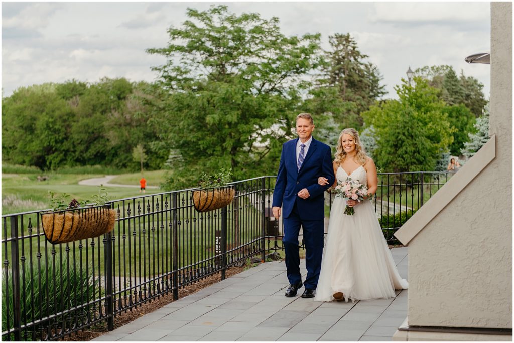 the bride and her father walking across the balcony at Mistwood Golf Club in Romeoville