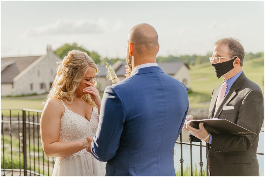 the bride crying as her groom is about to put a ring on her finger during sunset at Mistwood Golf Club in Romeoville