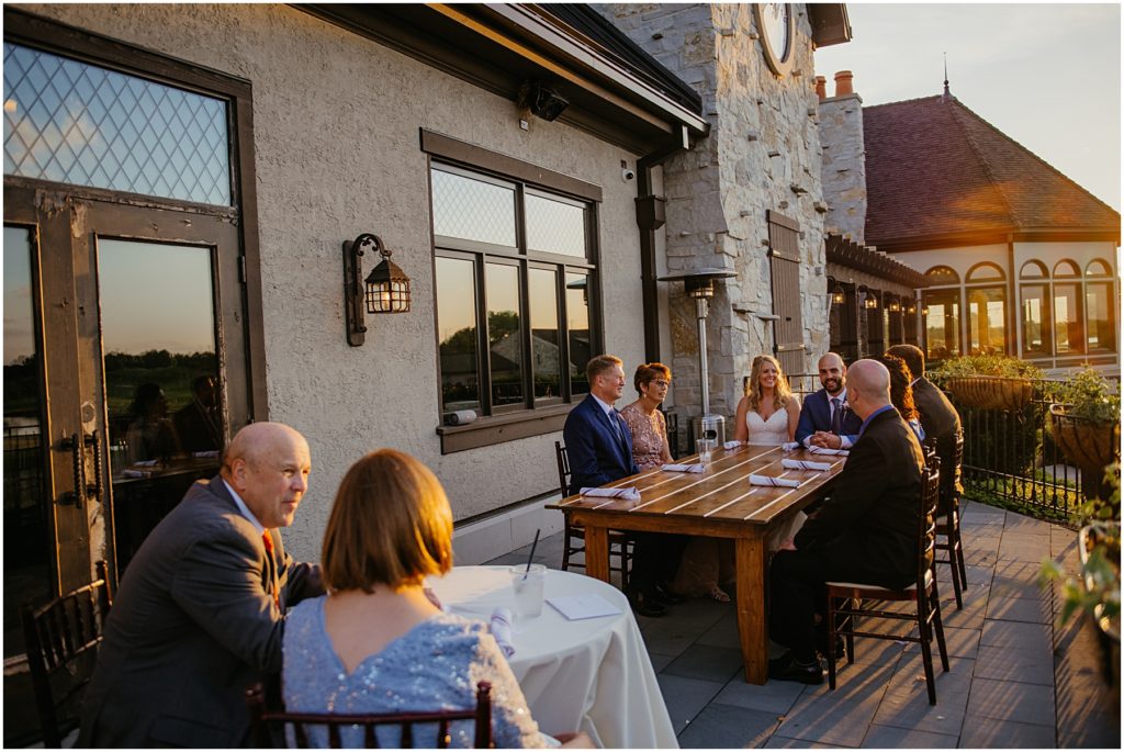a small wedding reception taking place on the balcony at Mistwood Golf Club during sunset at a couples micro wedding