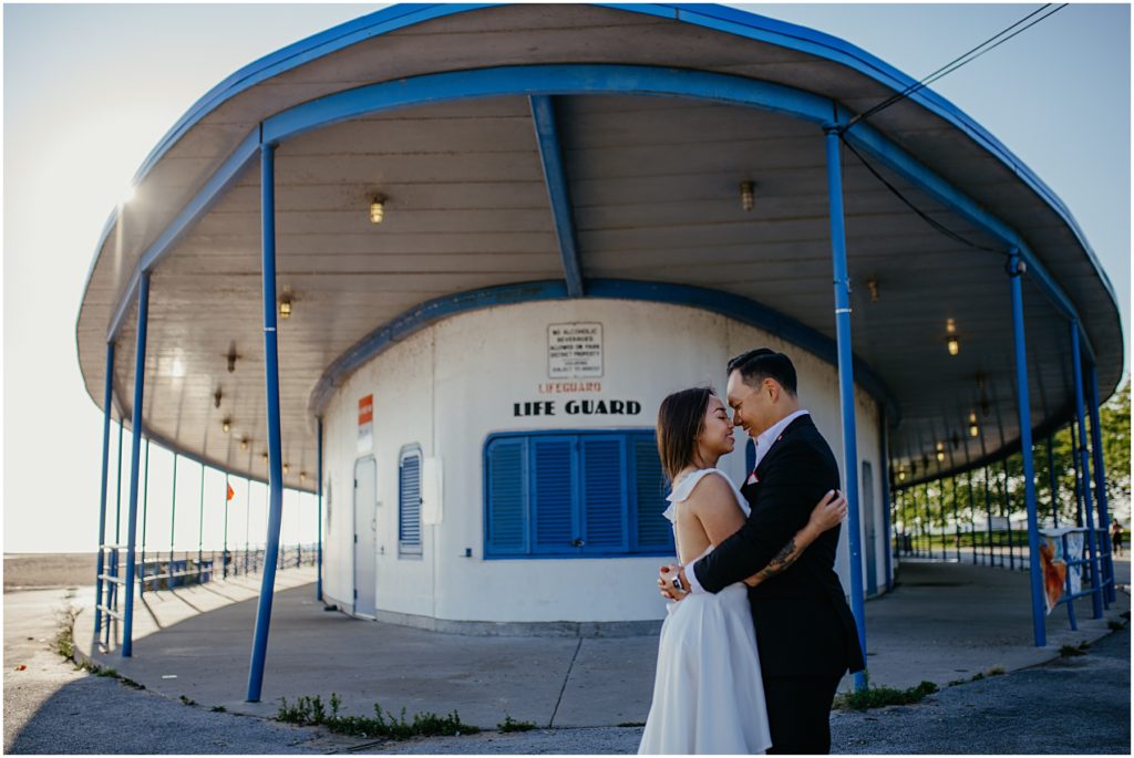 a man and a woman getting close together in front of the life guard house at their North Avenue Beach sunrise engagement session
