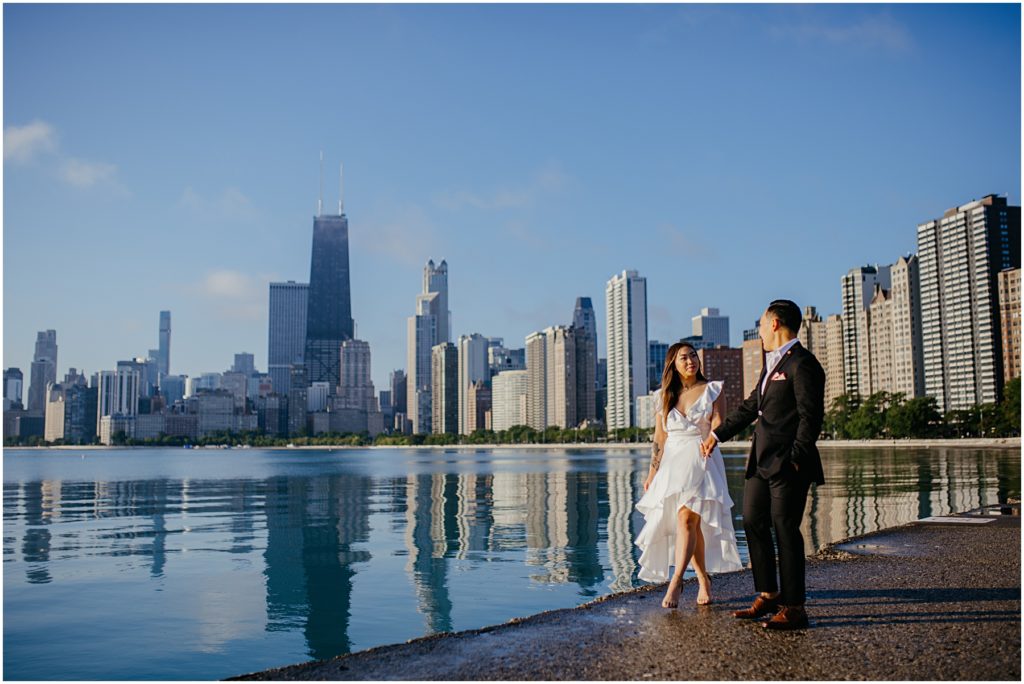 a newly engaged couple walking on the Chicago Lakefront at sunrise