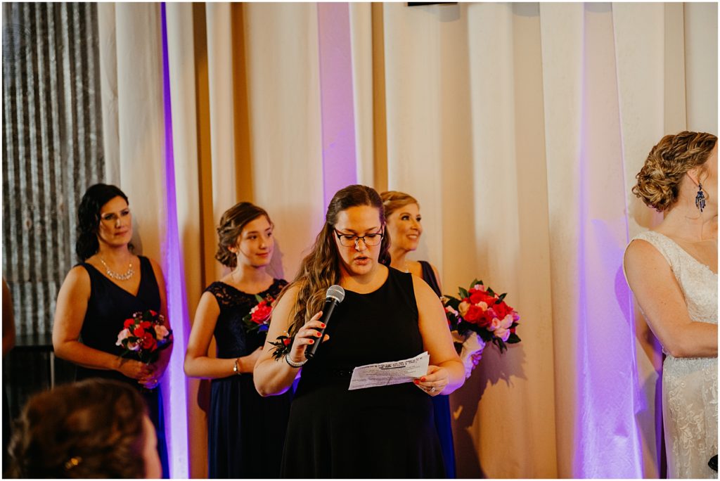 a good friend of the bride and groom reading a poem during the ceremony at their warehouse wedding