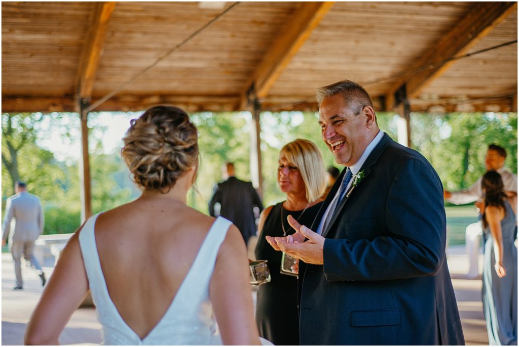 the father of the bride laughing with excitement during an outdoor intimate wedding