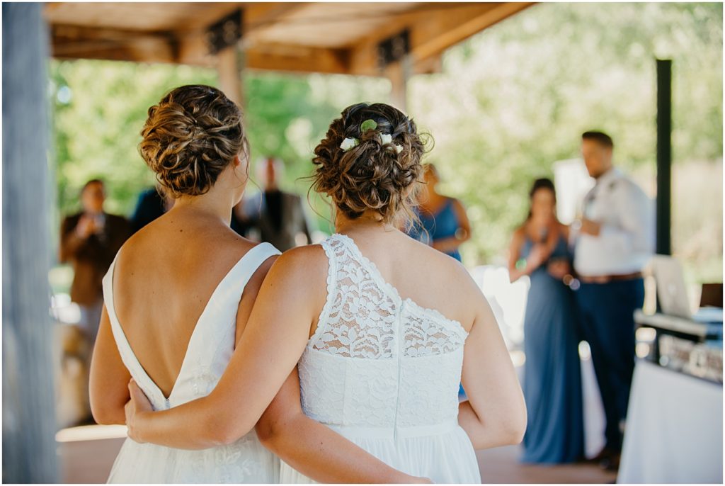 two brides with their arms around each other during their intimate wedding
