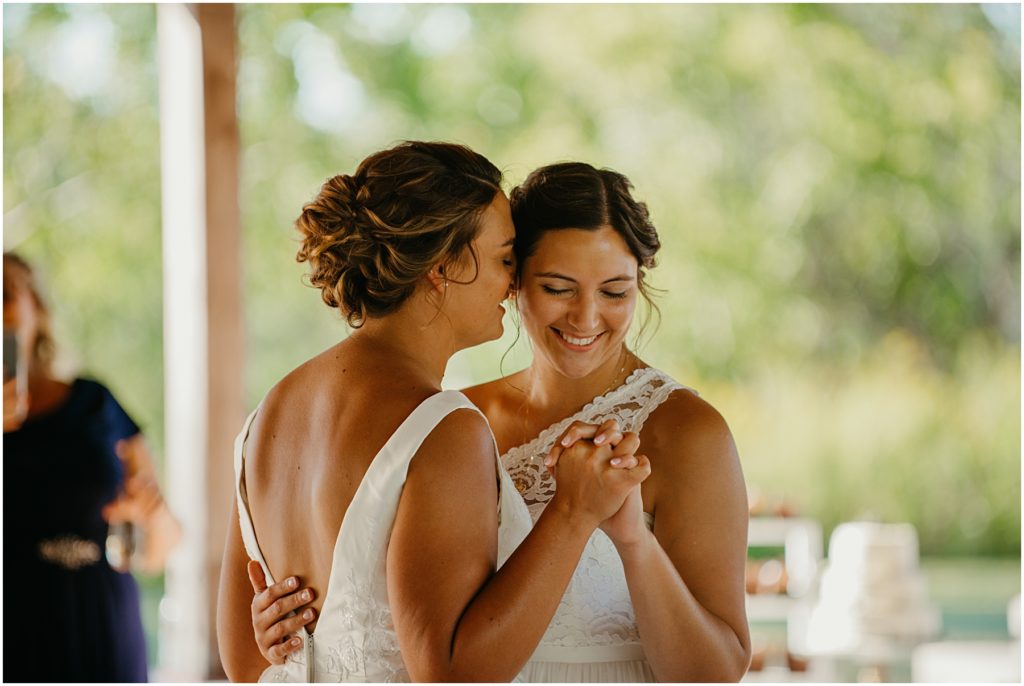 a bride kissing her brides head during their first dance at their intimate wedding in the fall